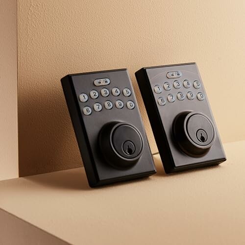 Two digital keypad door locks on a beige background.