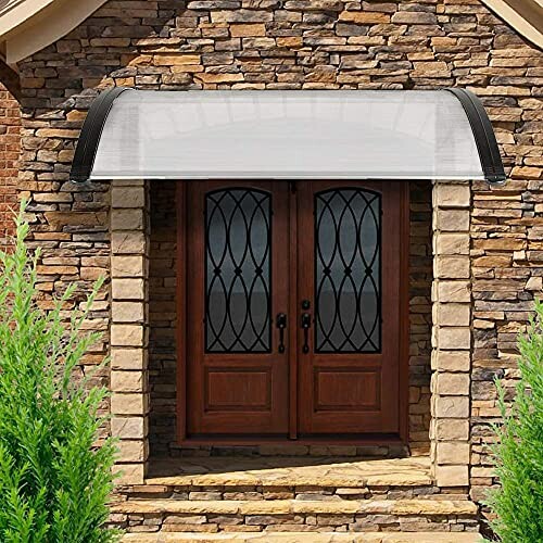 Stone house facade with double wooden doors and a curved awning.