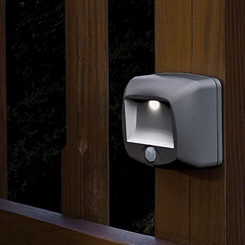 Outdoor motion sensor light on wooden fence