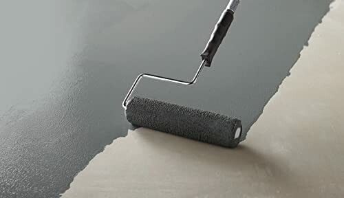 Paint roller applying gray coat on a surface