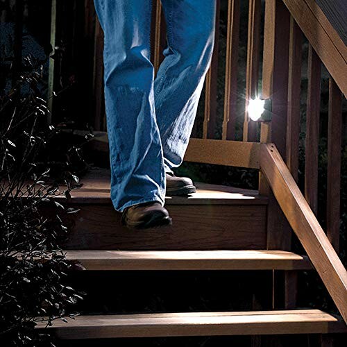 Person walking down wooden stairs at night with a light.